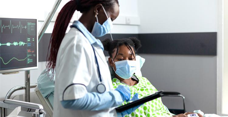 Doctor talking to child in hospital ward