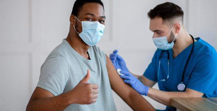 Black male thumbs up having a vaccine