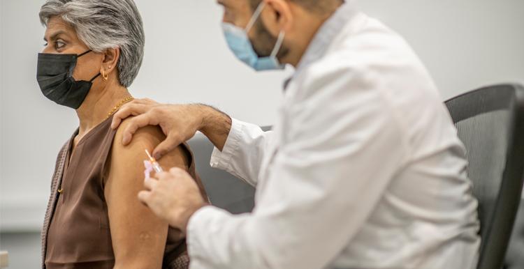 Older Asian woman receiving a vaccine