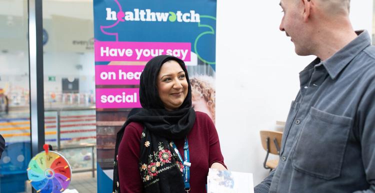 Asian woman and white man at a Healthwatch stall