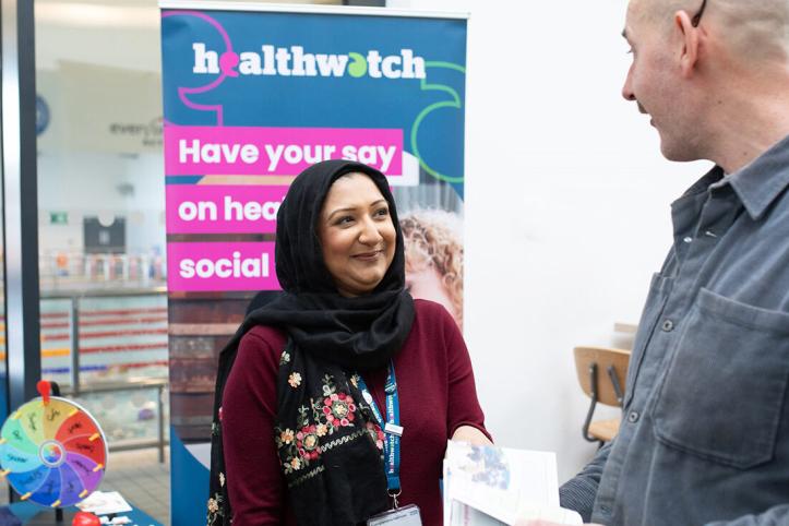 Asian woman and white man at a Healthwatch stall