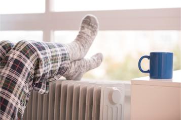 Person resting their socked feet on a radiator